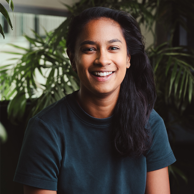 rhia patel smiles and wears a blue t shirt