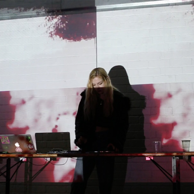 a woman on stage behind a laptop