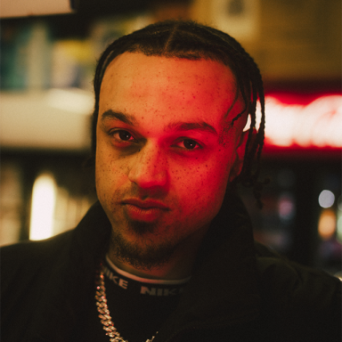 a nan with braids has a red hue across his face